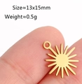 Golden stainless steel sun pendant charm 13x15mm displayed on a fingertip for scale - Sun / Gold