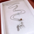 Vue détaillée d'un pendentif cheval argenté avec perle œil de tigre et pompon - Argenté