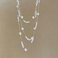 Elegante mehrlagige Perlenkette mit silbernen Diamantakzenten auf kaffeebraunem Hintergrund - Silber