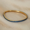 Gold plated tennis bracelet featuring vibrant blue round-cut zircon stones on silk - Gold Color/Dark Blue Zircon