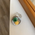 Makro-Detail des handgefertigten Perlenrings mit grünen Harzanhängern und Gummiband - Stil B Gelb Grün Perlen