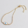 Close-up of golden evil eye sliding bracelet with micro-paved cubic zirconia stones - White