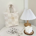 Dettaglio della borsa a secchiello in peluche a scacchi su scrivania minimalista - Scacchi Bianco