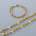 Dettaglio flat lay di un set di bracciale e collana a catena dorata lucida e lavorata - Bracciale 20CM / Oro