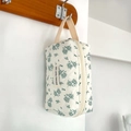 Detail of quilted cotton floral cosmetic bag hanging on a hook with woven strap - Mini Wristlet Bag / Off-white Green Floral