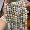 Handheld view of colorful natural Morganite and Beryl round beads for DIY jewelry - Single Strand Price / Grade A 14mm (Approx 27 Beads/Strand)
