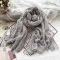 Grey and white plaid wool scarf with red stitching and tassels on a metal rack - Grey Grid
