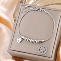 Macro shot of silver steel clover pendant bracelet on a grey luxury jewelry box - Silver B-247S (Hollow/Solid Clover)