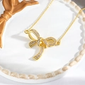 Macro view of a 18k gold plated bow pendant necklace with sparkling micro-pave crystals - Gold Pave Bowknot