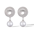 Close-up of geometric spiral earrings in silver with a large white hanging pearl detail - Spiral Pearl Dangle / Silver