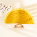 Minimalist yellow solid wood folding fan featuring matte finish and elegant classic ribs - Yellow