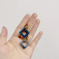 Detailed shot of vintage gold earrings with blue marbled square resin pendants - Square Fog Blue (Gold Hoop)