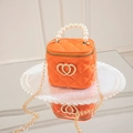 Mini orange jelly handbag with pearl handle and heart decor on a reflective surface - Orange