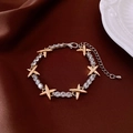 Detailed close-up of 18k gold plated cat eye opal bracelet on dark brown silk fabric - Gold-Silver Two-Tone Cross Zircon