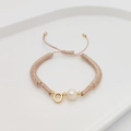 Close-up of handmade braided letter bracelet with white pearl and gold beads - Letter O