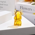 Macro di una statuetta di bue in cristallo giallo su un supporto con sfondo sfocato morbido - Bue dello Zodiaco / Giallo Oro