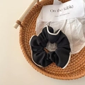 Black fabric scrunchie with white trim decoration shown in a woven tray - Black Goddess Contrast