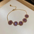 Macro view of 18k gold plated bracelet with purple zircon flower pendants and O-chain detail - Gold-Purple