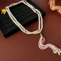 Detalle de collar de cuentas con colgante de loto dorado y borlas de cristal rosa - Blanco