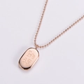 Collana in acciaio al titanio placcato oro rosa con pendente ovale e catena a sfere su grigio - Oro rosa