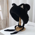 Detailed view of black plush earflap hat with cat ears on a wooden stand - Black
