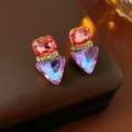 Makroaufnahme von Vintage-Ohrringen mit roten und blauen Kristallen auf braunem Leder - Silberstift Rot-Violette Ohrringe