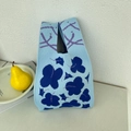 Close-up of light blue knitted tote bag featuring dark blue flower patterns and textures - Small Flowers Blue
