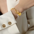 Gold U-link chain bracelet with white pearls and heart pendant on a wrist - 20cm / Gold
