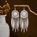 Detailed view of silver bohemian tassel earrings hanging on a rustic wooden branch - Silver Radial Disc Tassel(E2875-29)