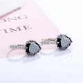 Close-up of heart-shaped black gemstone earrings with pavé white zircon in silver setting - Black Zirconia