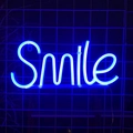 Blue LED neon Smile sign mounted on a black wall grid for interior ambient lighting - Blue