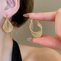Close-up of golden multilayer twisted oval earrings showing high-end metallic texture - 73# Ear Buckle - Gold Multi-Layer Twisted