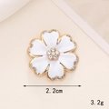 Vue détaillée d'une fleur émaillée blanche de 2,2cm avec bord doré et strass au centre - D886 Fleur Hexagonale