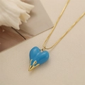 Detailed close-up of blue heart pendant with melting gold texture on box chain necklace - Blue