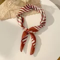 Elegant silk scarf featuring brown and cream diagonal stripes with a decorative knotted style - Orange