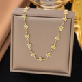 Detail of elegant gold daisy necklace with white enamel petals on a jewelry display box - White Daisy Necklace (H6140) / Gold