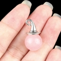 Pink quartz witch hat pendant with silver metal bail held on a finger fingertip - Rose Quartz