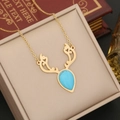 Detailed shot of golden antler necklace with turquoise stone in a jewelry gift box - Necklace