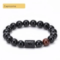 Detailed macro view of black agate beads and engraved Capricorn symbol on zodiac bracelet - Capricorn