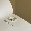 Macro shot of silver ring with colorful heart gemstones on an open book page - Adjustable Open / Multi-colored Heart Gem Style (J3364)