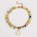 Detail of gold chain anklet with colorful beads and white five-petal flower pendant - Bracelet