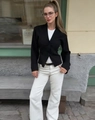 Primo piano di un blazer corto nero slim fit con due bottoni e un elegante rever a lancia - S / Nero