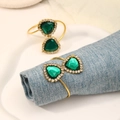 Elegant gold napkin rings with green heart gemstones and rhinestones on blue cloth - Z1186-GR (Green Double Heart Rhinestone)
