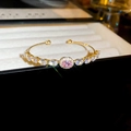 Detail of gold-plated open bangle with pink gemstone and sparkling white zircons - Bracelet-Gold