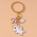 Cartoon unicorn keychain with purple umbrella and smiling cloud charms on gold ring - Unicorn