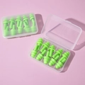 Macro detail of green silicone earplugs in clear plastic storage cases on pink background - Green (5 Pairs)