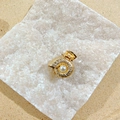 Golden conch alloy hair claw clip with pearl accent on a decorative white stone - Conch Claw Clip