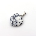 Polished Dalmatian stone heart pendant with a silver stainless steel bail on white backdrop - Black and White Spotted Stone