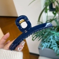 Close-up of a large glossy navy blue hair claw clip with a strong gold metal spring - Sapphire Blue