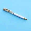 Dettaglio macro della penna a sfera in cristallo bianco con inserti dorati e pietre - Refill Nero 14cm / Citrino